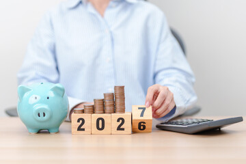 Fototapeta premium 2026 end year to Happy New Year 2027 with piggy bank. Resolution, Goals, Plan, Action, Money Saving, Retirement fund, Pension, Investment and Financial concepts