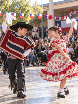 Chilean children dancing cueca in huaso costume for Fiestas Patrias event