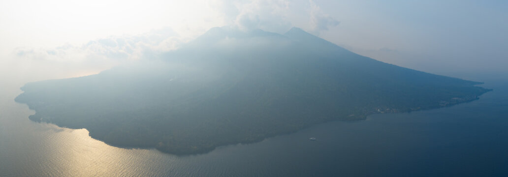 Late afternoon sunlight shines on the volcanic island of Makian, just south of Ternate near Halmahera, Indonesia. The coral reefs of this region support extraordinary marine biodiversity.