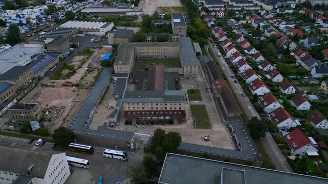 Berlin memorial former prison camp complex with surrounding residential area and urban landscape under cloudy sky. Unbelievable aerial view drone camera pointing down