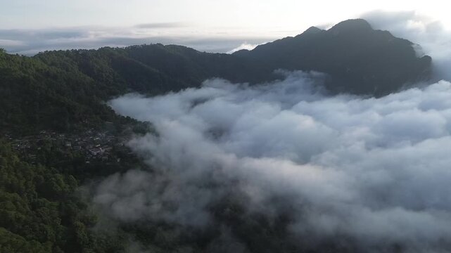 Misty Mountain Ridge Forest Valley Aerial Landscape with Rolling Cloud and Fog, Layered Nature Views, Remote Settlement Beneath Muted Morning Sky, Serene Atmospheric Wilderness Scene