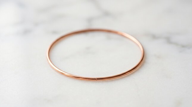 Minimalist copper wire circle on a soft focus white marble background