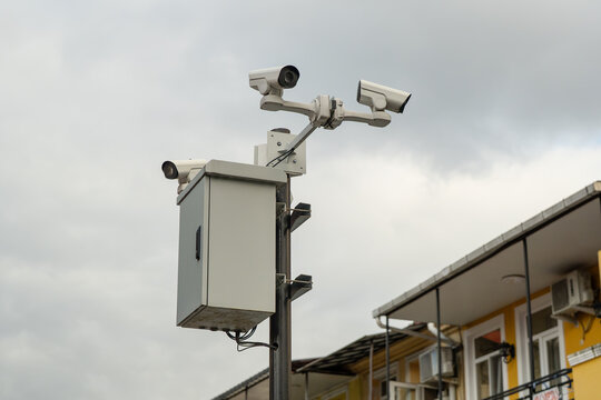 AI-powered video surveillance cameras mounted on city pole for control and safety in public space, multiple security cameras and metal box on post for surveillance and security monitoring urban street