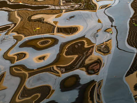 Abstract Golden and Blue Water Reflections of Buildings, Distorted Urban Ripple Texture