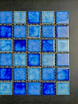 Abstract geometric background featuring a grid of glossy blue ceramic mosaic tiles