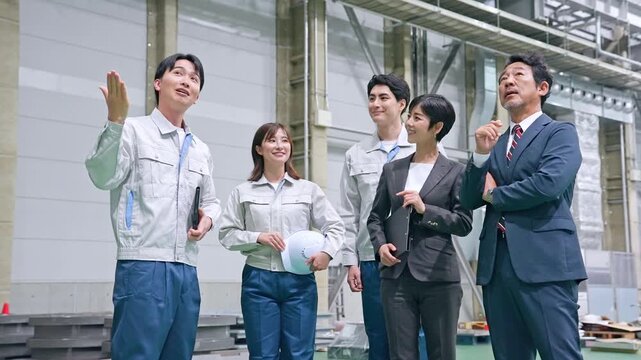 訪問者に工場を案内する男性作業員