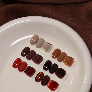 A close-up photograph of various nail polish colors on a tabletop.