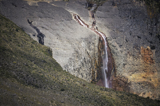 Waterfall cascading down rocky cliff in Los Nevados National Park, Colombia