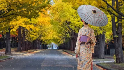 Young Japanese woman in a traditional Kimono dress with scenic autumn view at Hokkaido University's Ginkgo Avenue in Sapporo, Hokkaido, Japan © coward_lion