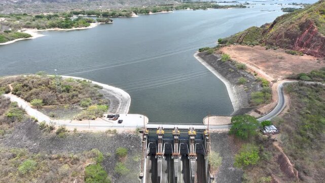 Hydroelectric Dam and Reservoir with Spillway and Energy Infrastructure. Establishing Shot. Aerial View.