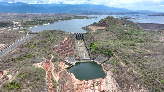 Hydroelectric Dam and Reservoir with Spillway and Energy Infrastructure. Establishing Shot. Aerial View.