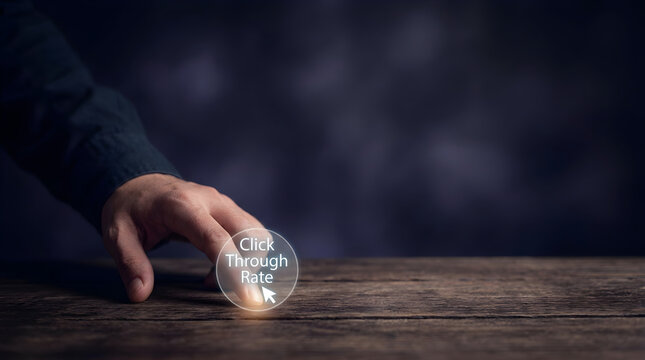 Person touching a digital button for click through rate on a rustic wooden table surface