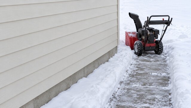 Snow Blower at End of Cleared Residential Walkway