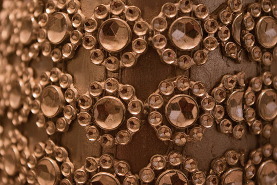 Close up full frame texture of sparkling rhinestones arranged in a floral geometric pattern
