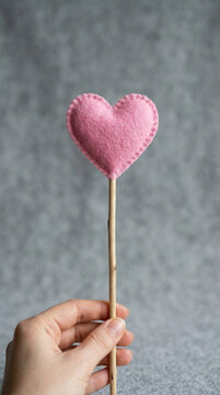 Pink Felt Heart on Wooden Stick Held by Hand Handmade Love Symbol Soft Fabric Craft Valentines Day Decor