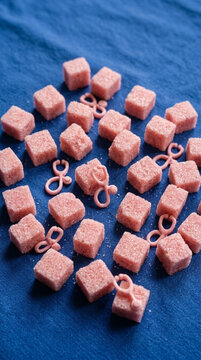Pink Sugar Cubes Arranged on Blue Fabric Background with Tiny Pink Stethoscopes Sweet Health Concept
