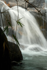 A serene waterfall cascades over rocks, creating a misty atmosphere. © k33pcalmncapture