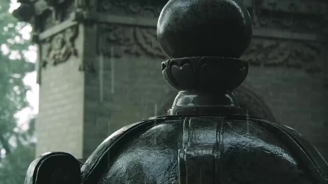 Rain falling on a traditional Chinese stone lantern with ornate carvings and tiled roof background
