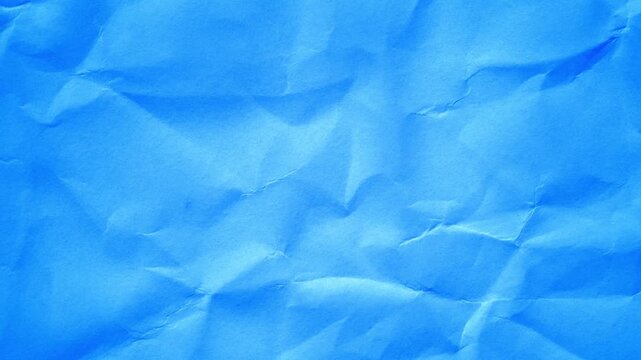 Bright blue crumpled paper texture shifts frame by frame in a seamless stop motion loop, creating tactile folds, soft shadows, and playful handcrafted animation style