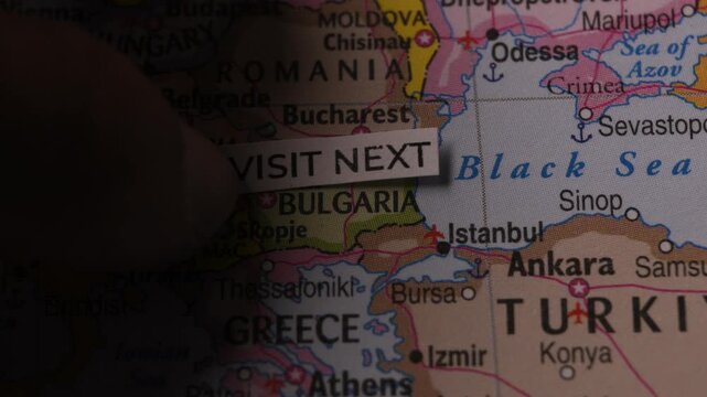 Paper tag reading Visit Next on a map of Europe and Bulgaria for travel concept