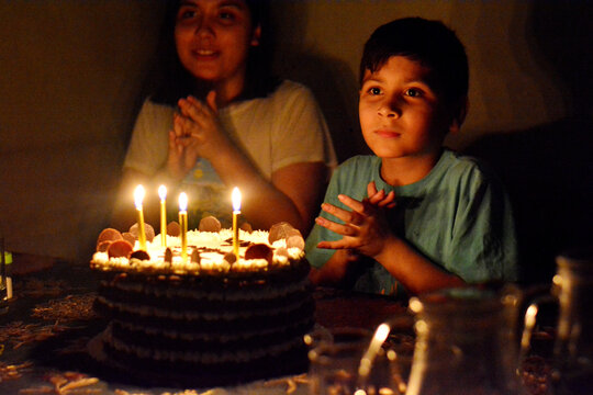 Clapping dreamy boy and birthday cake.