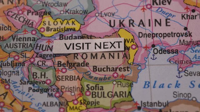 Hand Placing Visit Next Label on Eastern Europe Map for Travel Planning