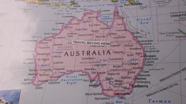 Travel Begins Here sticker placed on Australia map for vacation planning