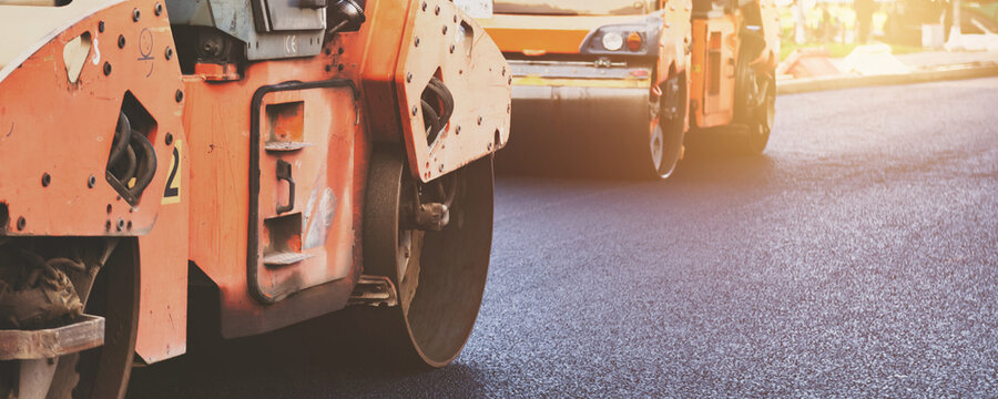 Road Rollers Compacting Fresh Asphalt Pavement on a Busy City Street