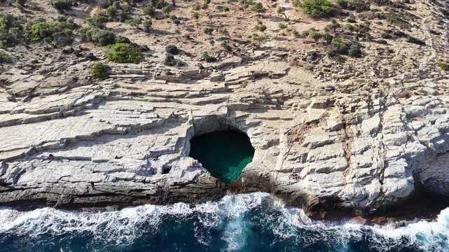 Cinematic horizontal aerial drone view of the famous Giola natural rock pool and the crashing Aegean sea waves in Thassos, Greece &ndash; 2026