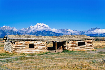 Old log house on the prairie at the rocky mountains a sunny autumn day with snow covered peaks © Lars Johansson