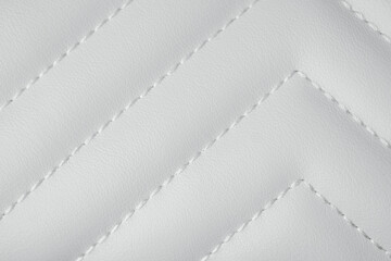 Fototapeta premium Detailed close up of white quilted leather texture with decorative chevron stitching pattern
