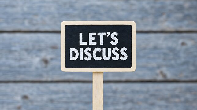 Lets discuss message on a small blackboard against a rustic wooden background