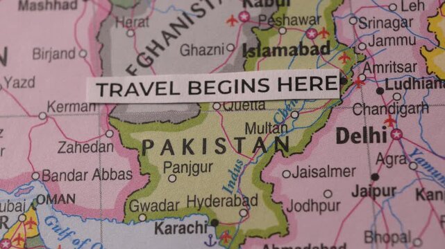 Paper slip with Travel Begins Here message placed on South Asia map