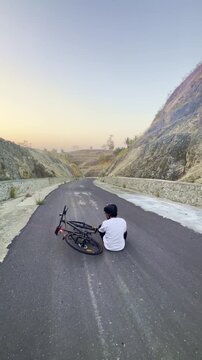 Cyclist Resting on a Remote Mountain Road