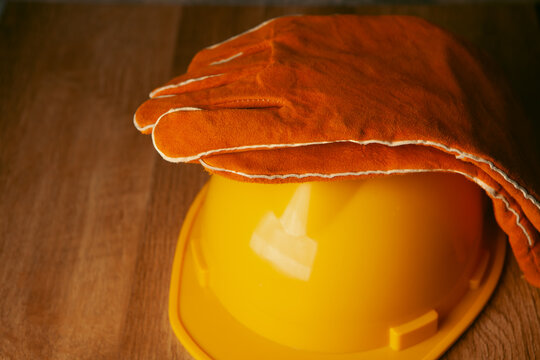 Hard hat and gloves on a wooden table.