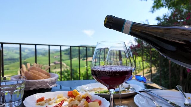 Pouring Red Wine Into Glass on Outdoor Restaurant Terrace Overlooking Vineyards