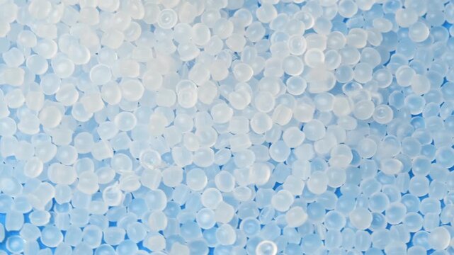 Polymer pellets fall onto rotating granules for medical and industrial manufacturing processes.