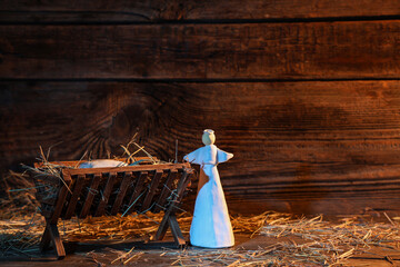 Fototapeta premium Manger with baby Jesus, angel and hay on wooden table