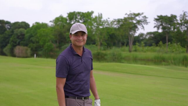Portrait of professional male golfer holding his club at golf course. 