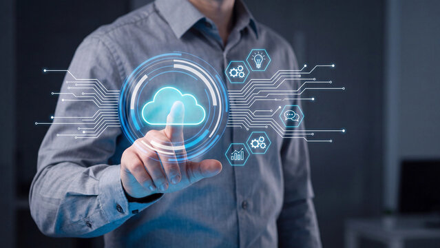 Professional businessman interacting with futuristic glowing cloud computing data interface using his index finger