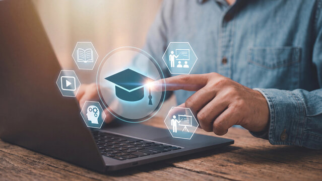 Focused student using laptop interacting with glowing graduation cap and e-learning icons