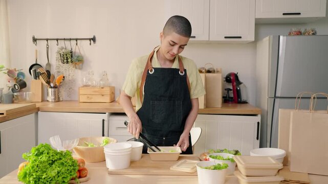 Caucasian woman preparing multiple salad boxes for small food business.