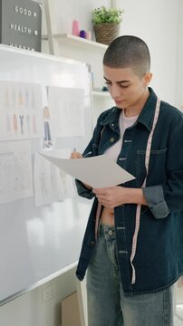 Caucasian young woman working as fashion designer in tailor studio.