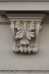 lose up architectural detail of a historical building facade featuring a decorative white stucco corbel bracket with carved acanthus leaf ornaments. © nahhan