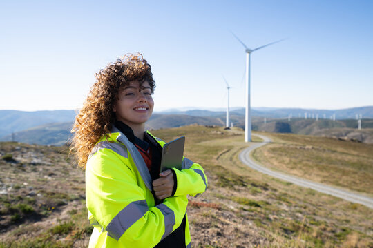White woman with tablet at wind farm in Galicia Spain