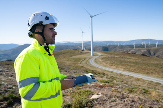 Engineer inspecting wind turbines on a wind farm in Galicia, Spain