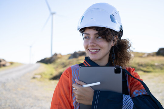 White woman engineer working with a tablet at a wind farm in Galicia