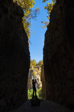 Photographer taking pictures in a narrow Abandoned Quarry at tarn