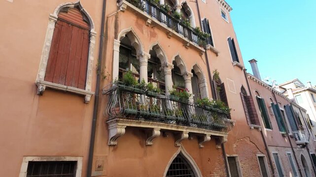 Ornate Venetian palazzo balcony facing a narrow historic street