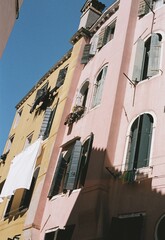 Fototapeta premium analog film photo of traditional buldings in a channel in Venice in Italy on a sunny summer day with blue sky